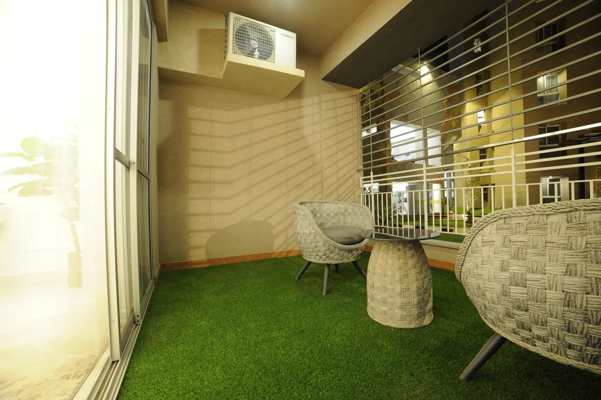 Sunlit residence terrace with cushioned seating, planting and a long view.